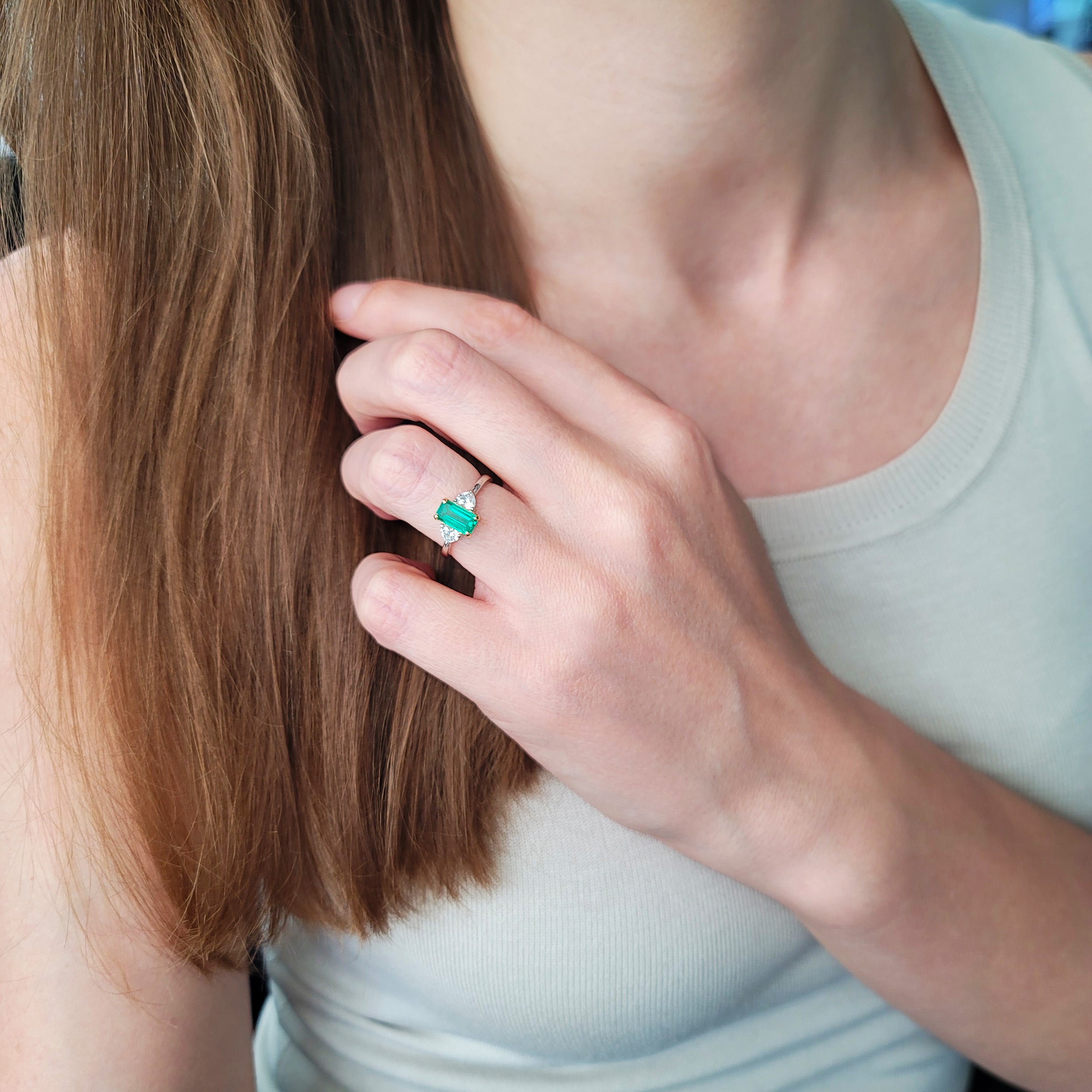 Rectangular emerald and heart shape diamond ring in platinum and 18k yellow gold.
