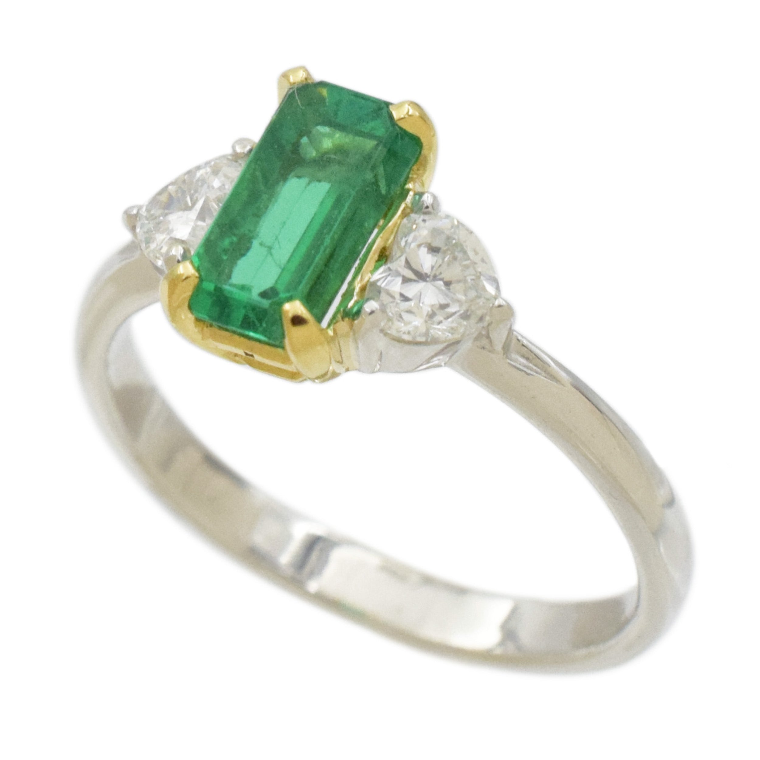 Rectangular emerald and heart shape diamond ring in platinum and 18k yellow gold.