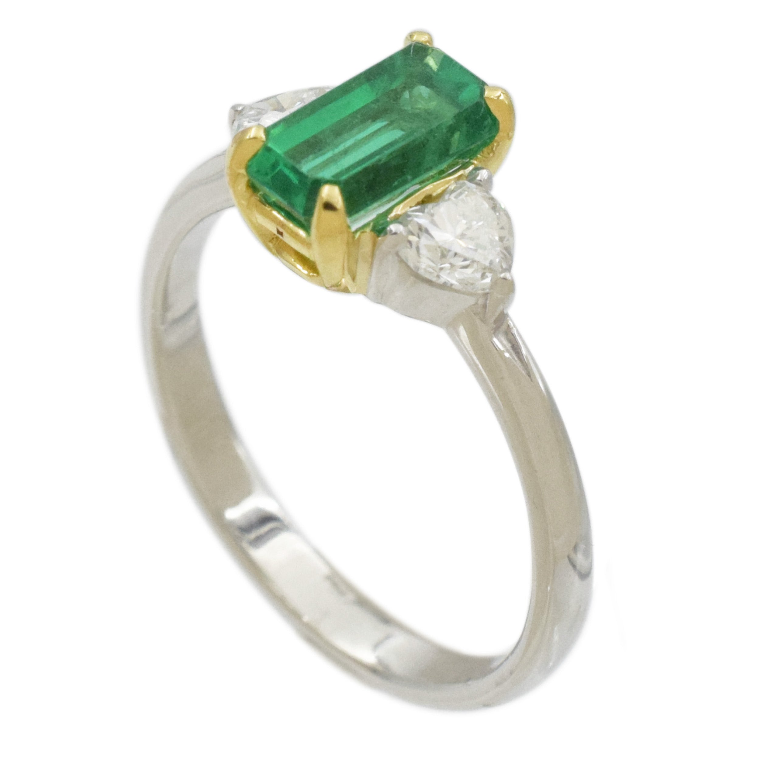 Rectangular emerald and heart shape diamond ring in platinum and 18k yellow gold.
