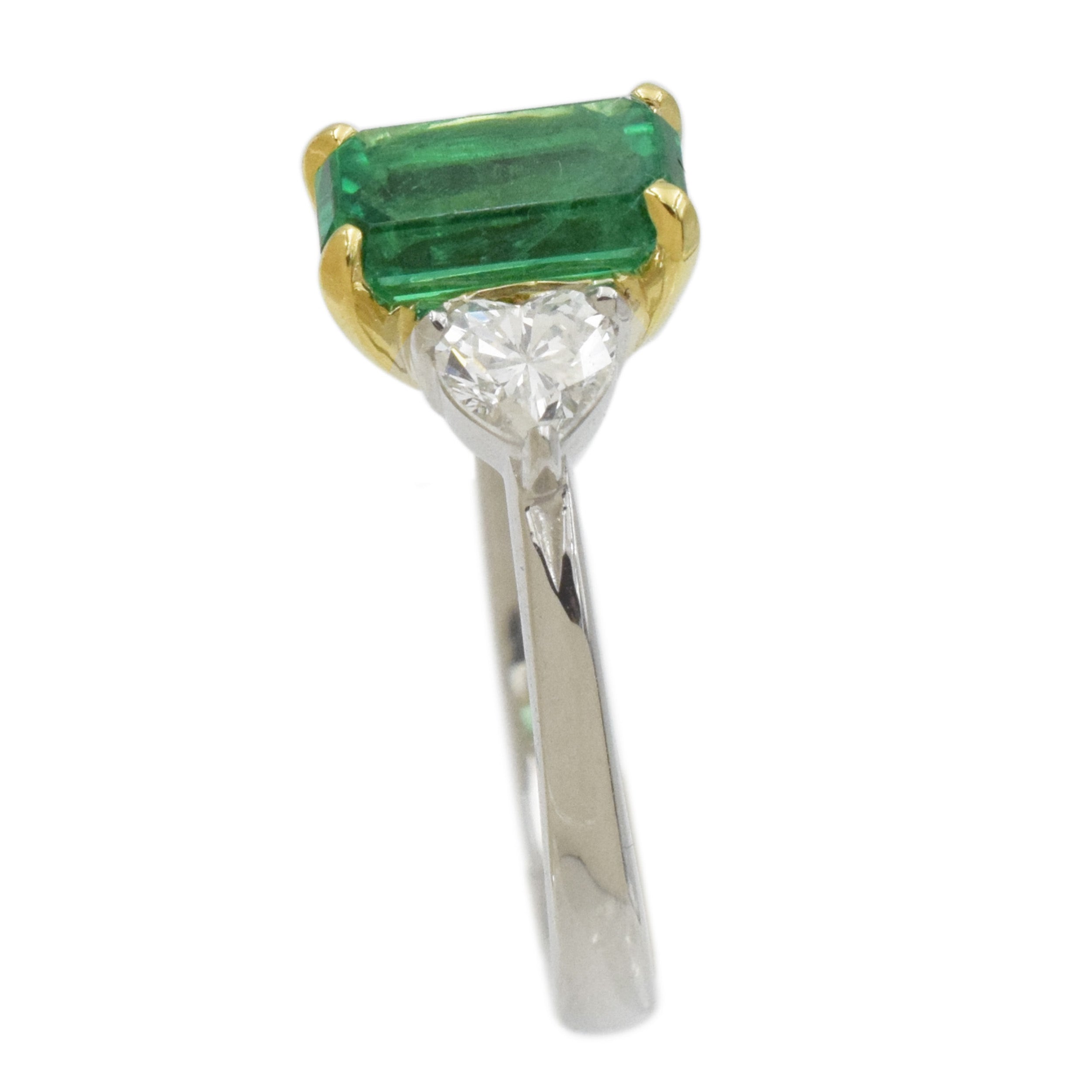 Rectangular emerald and heart shape diamond ring in platinum and 18k yellow gold.
