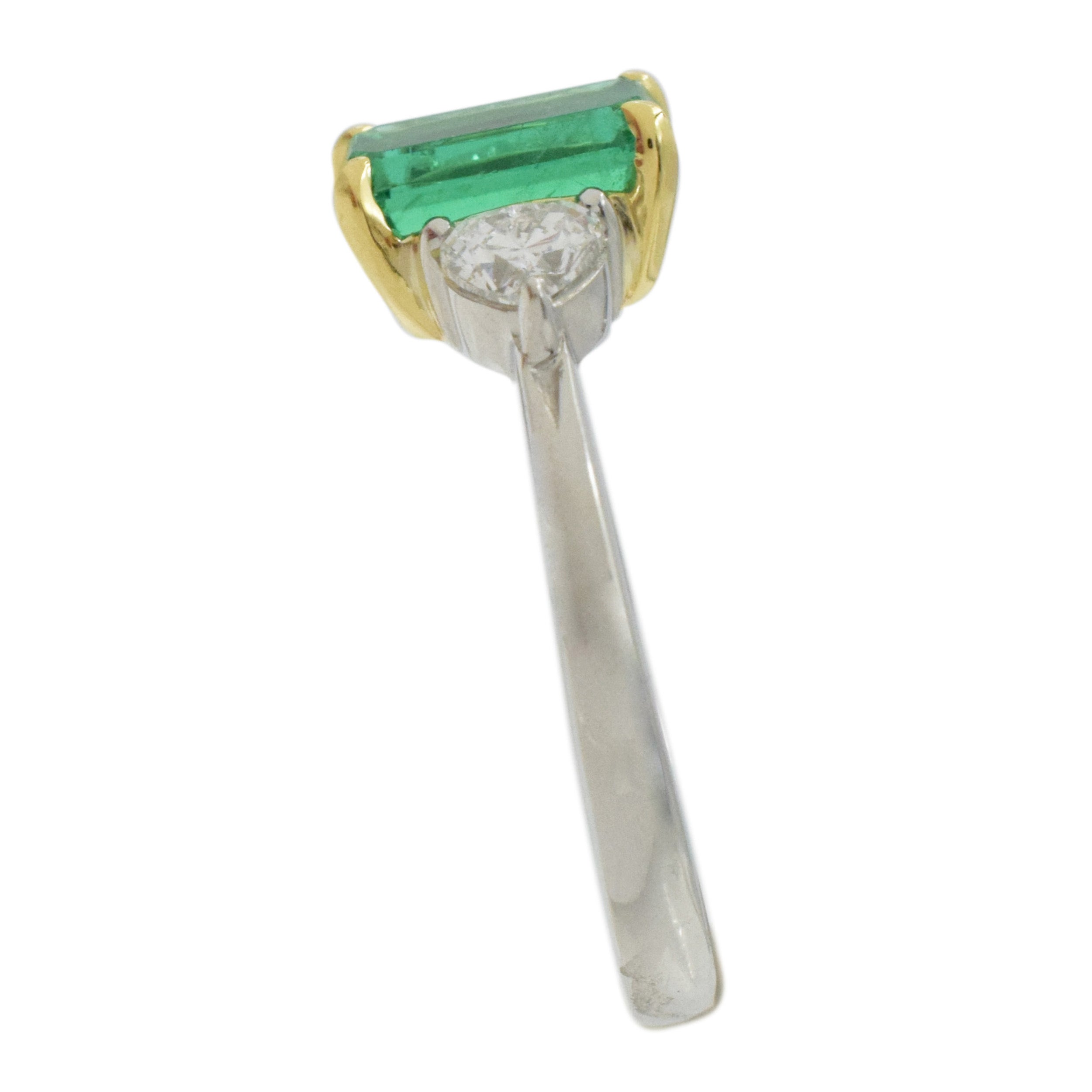 Rectangular emerald and heart shape diamond ring in platinum and 18k yellow gold.