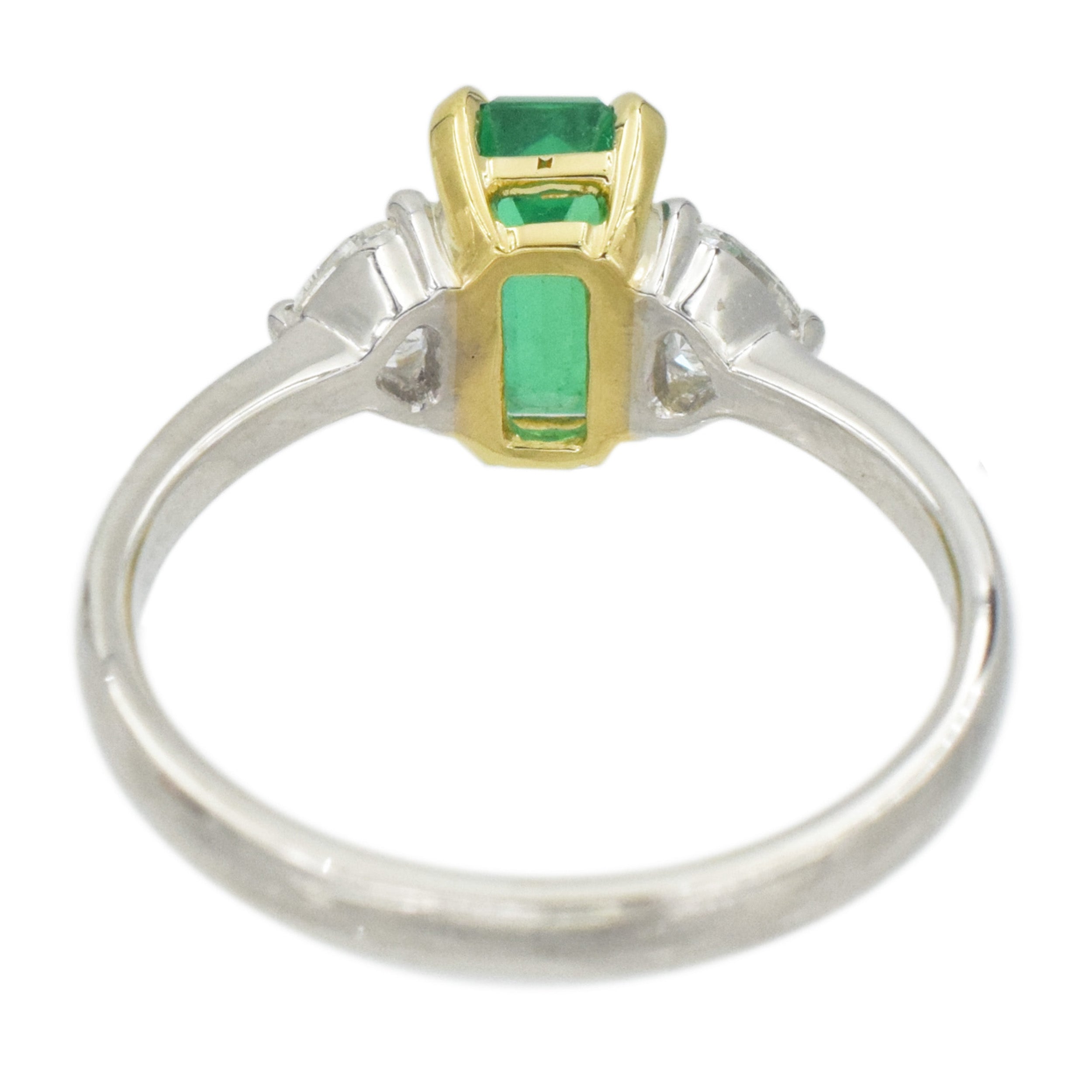 Rectangular emerald and heart shape diamond ring in platinum and 18k yellow gold.