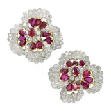 Stunning ruby and diamond earrings by Oscar Heyman, crafted in platinum and 18k yellow gold, designed as large flower blossoms encrusted with 144 round brilliant cut diamonds and accented with 22 oval shaped rubies, secured with omega fastening.  Diamonds total weight approx. 16.5ct. Color range from E fo F Clarity range VS+  Rubies total weight approx. 7.5ct.  Measurements 36mm by 37mm Weight 49g.  Stamped Plat, 18k and numbered   Ref# 810-000-1987